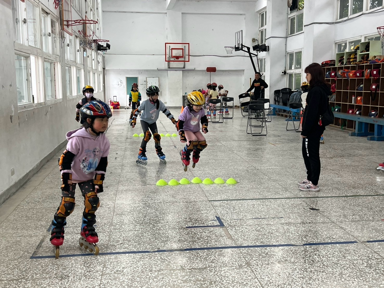 學生穿戴安全護具在活動中心練習直排輪滑行